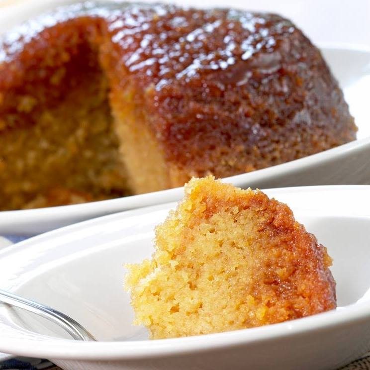 Golden syrup sponge pudding sliced open on a white plate at The Pudding Club, Three Ways House Hotel