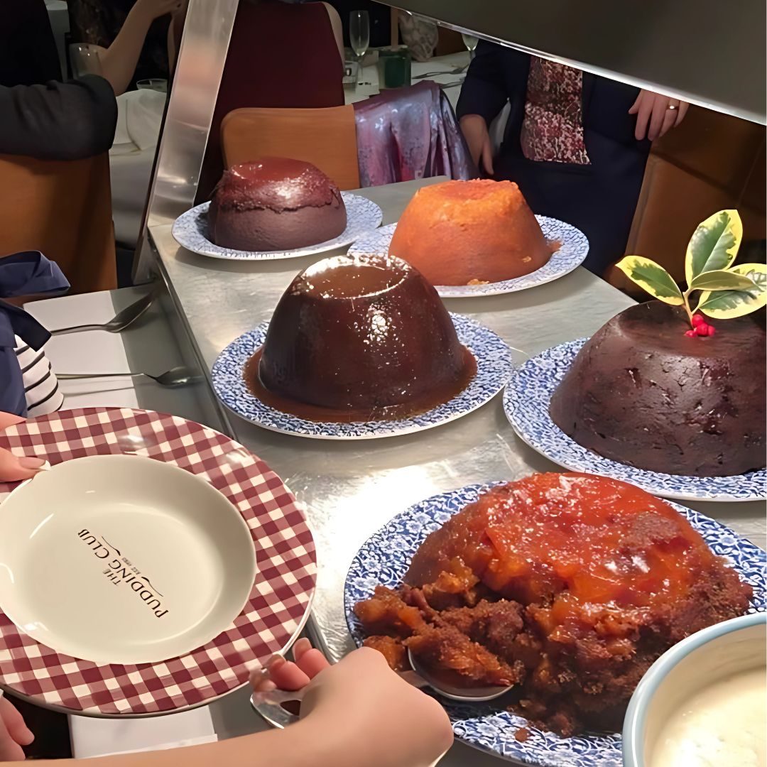 The Parade of Seven Puddings on the serving trolley with branded Pudding Club plates at Three Ways House Hotel